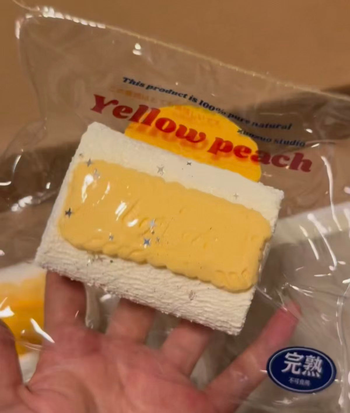 イエローピーチの白いケーキ（四角、パッケージ入り、オレンジ層）