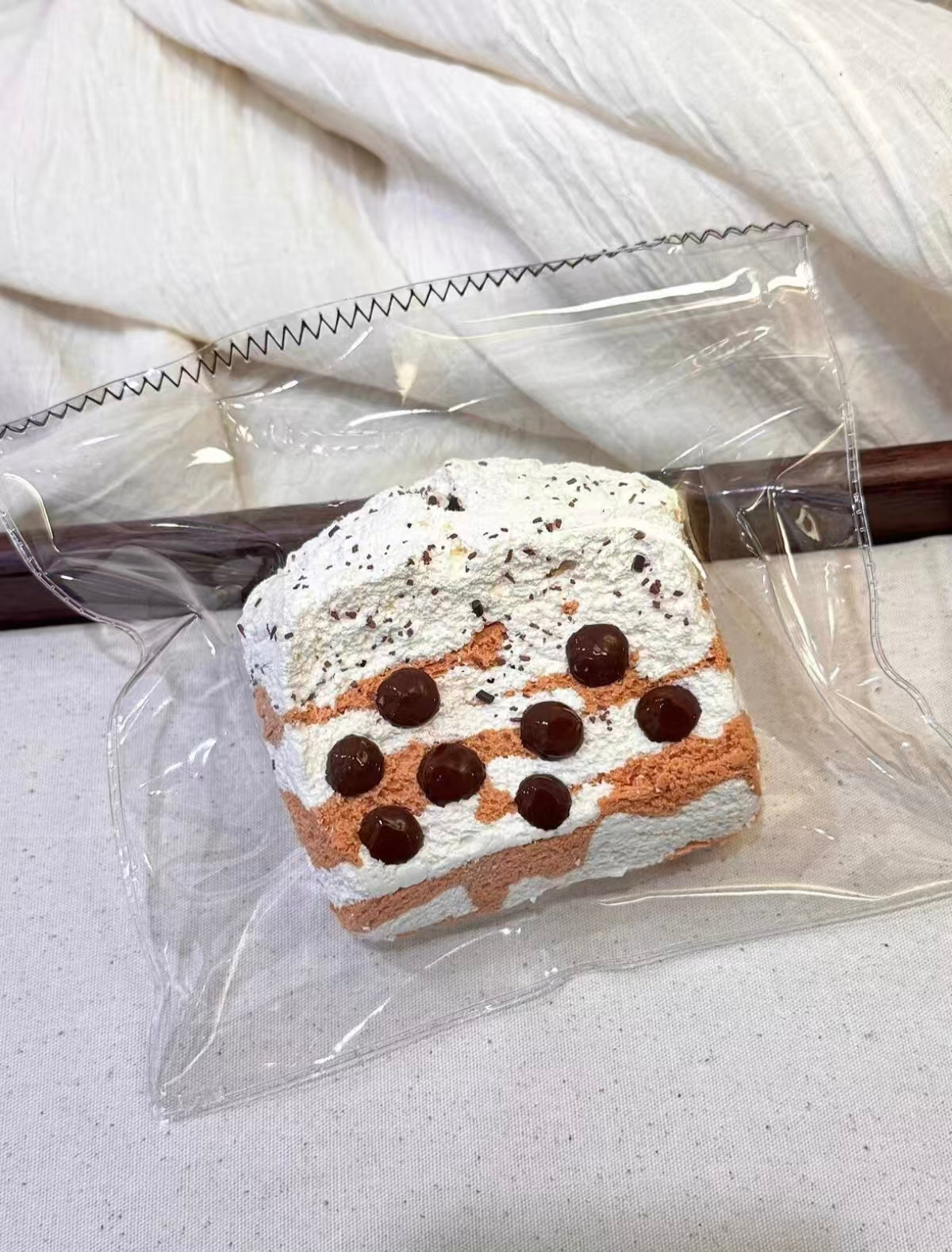 包装されたケーキスライス、白い生地にチョコの丸い粒と点模様