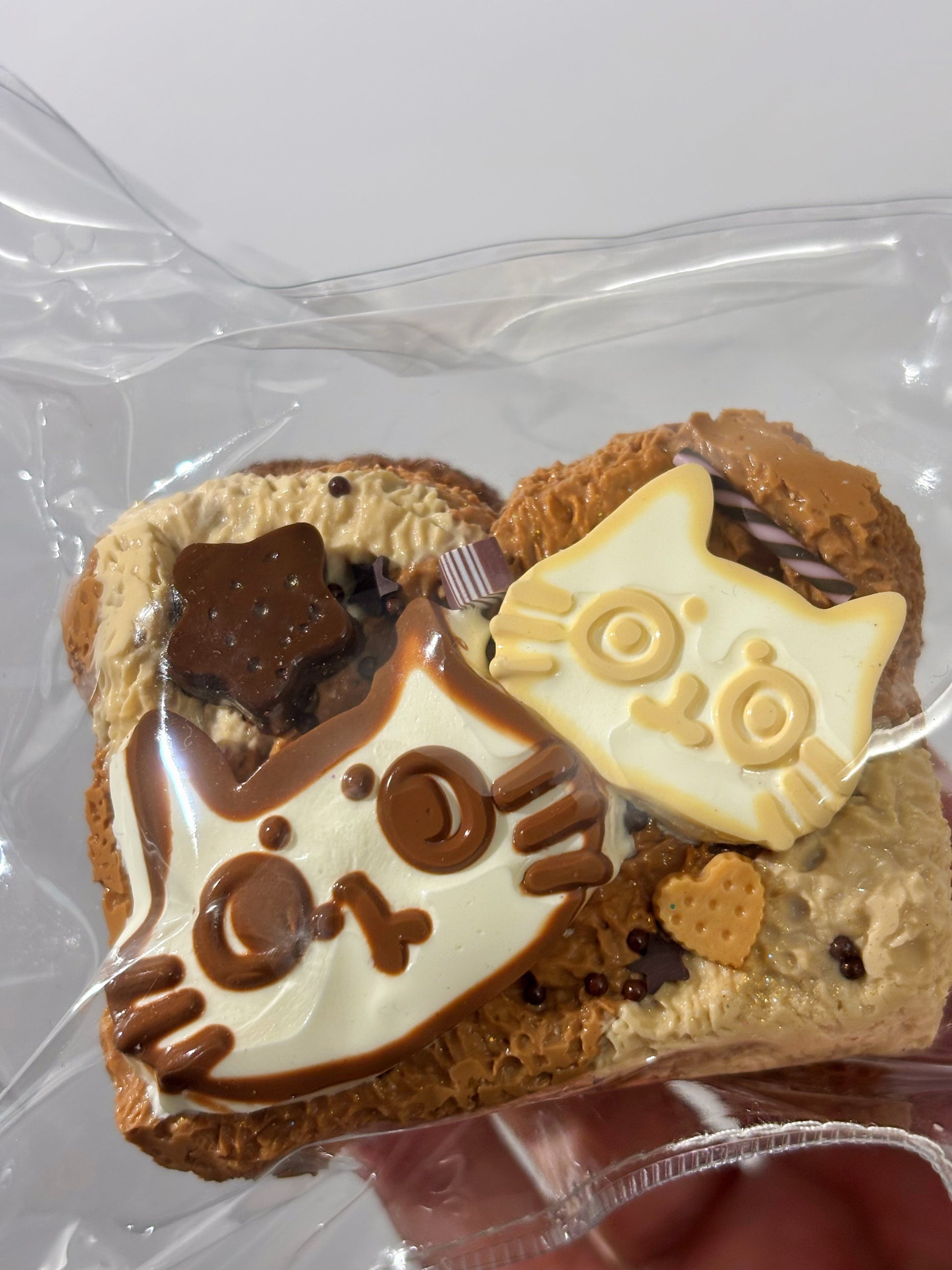 焼き菓子、楕円型。白と茶色のキャラ飾り、チョコとクッキー片が散らされる