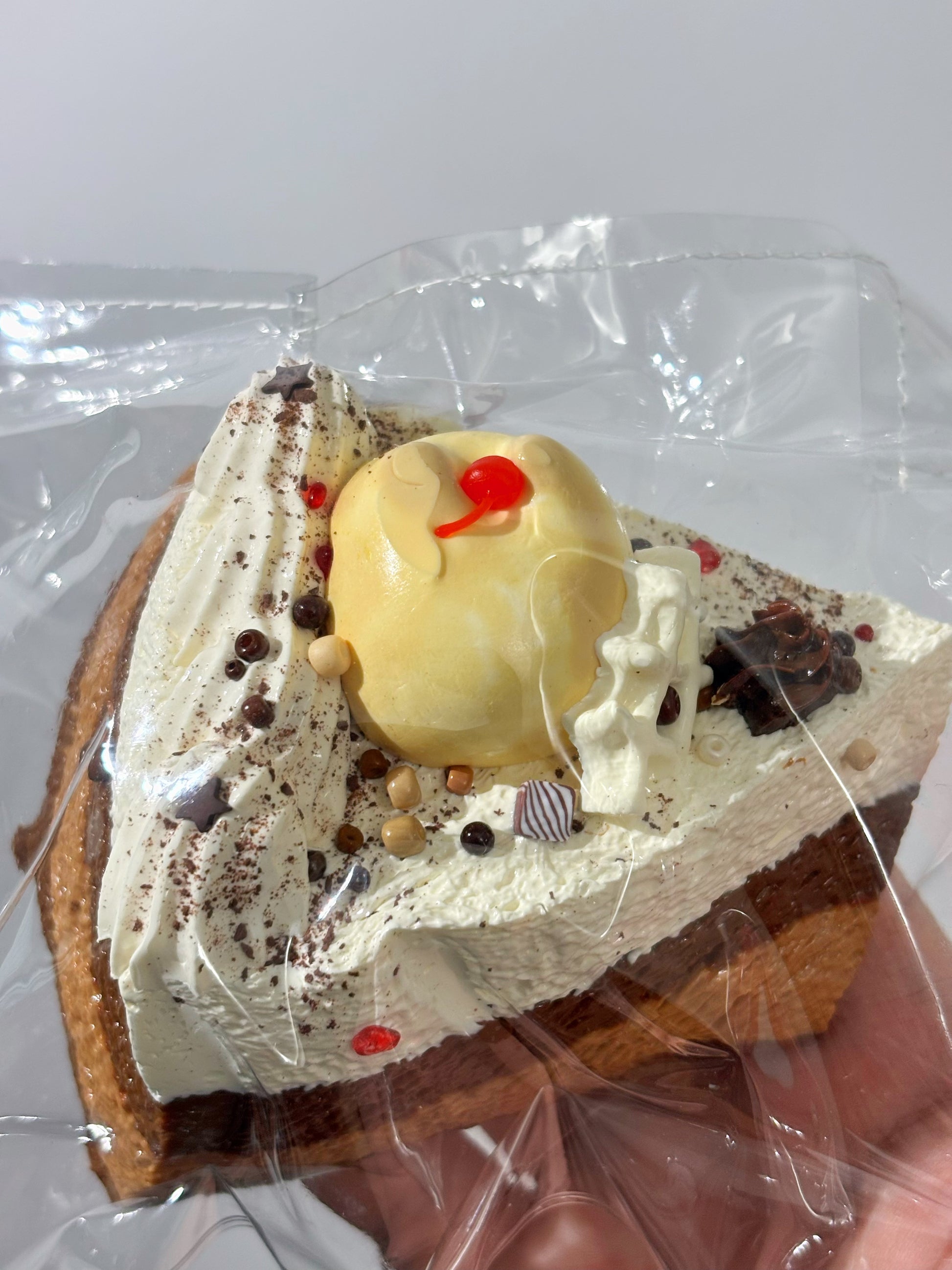 焼き菓子、チョコとクリームでデコ。黄色い顔モチーフと赤いリボン風アクセント