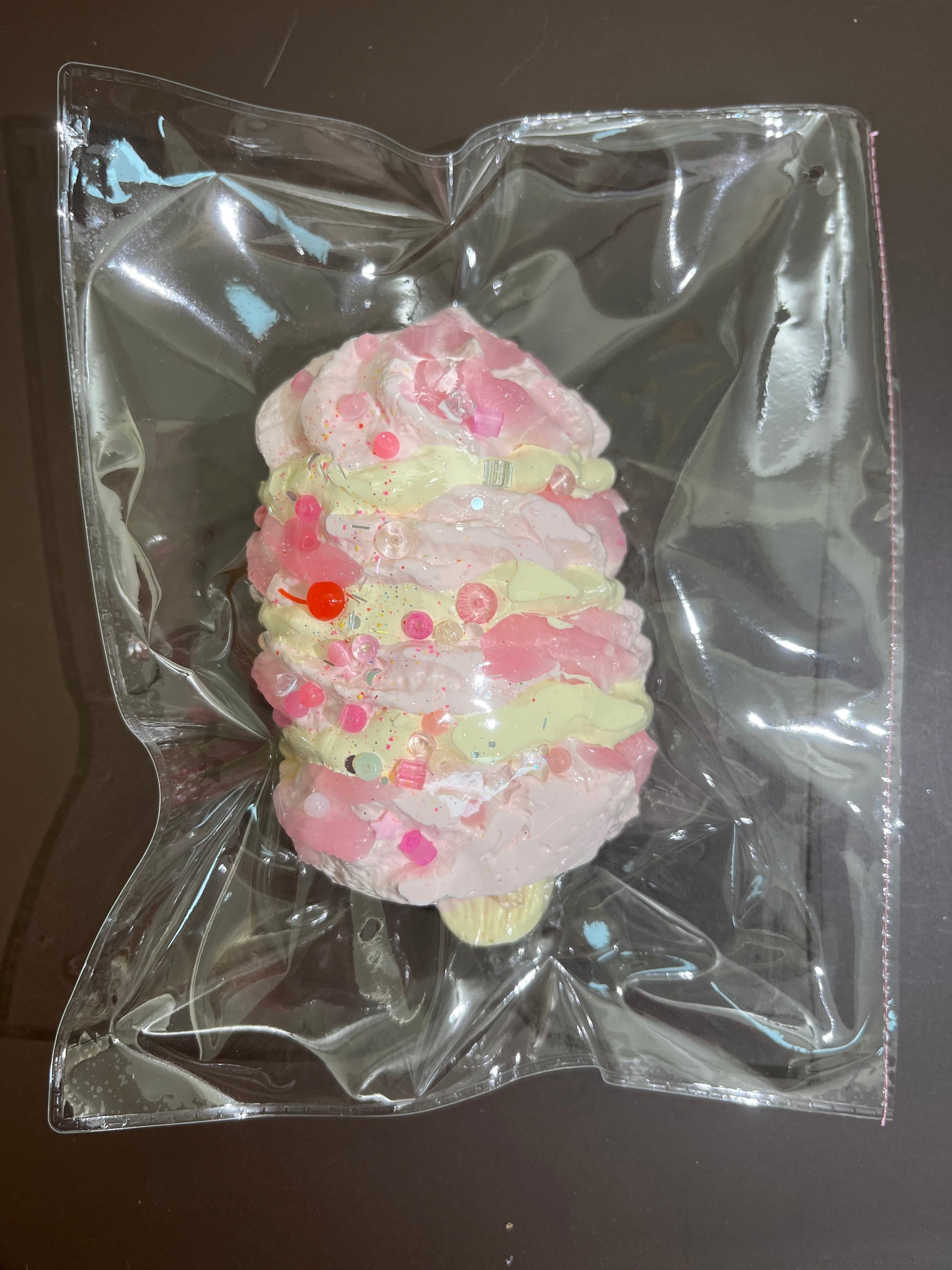 丸型ぬいぐるみ風モチーフ、ピンク系の層にレッドやグリーンの点飾り