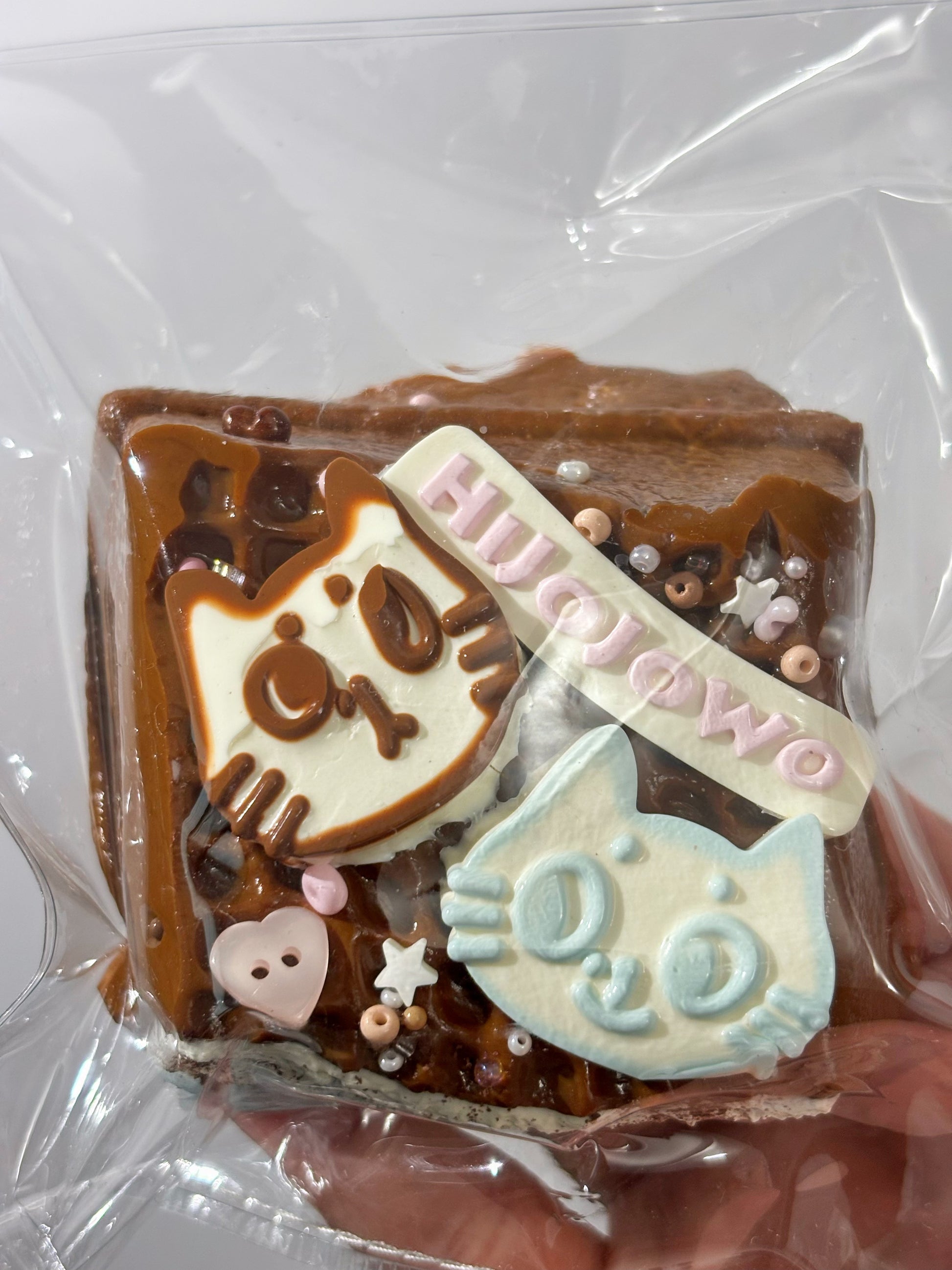 焼き菓子、四角いプレート状。チョコと白いキャラ、ピンクの棒状飾り