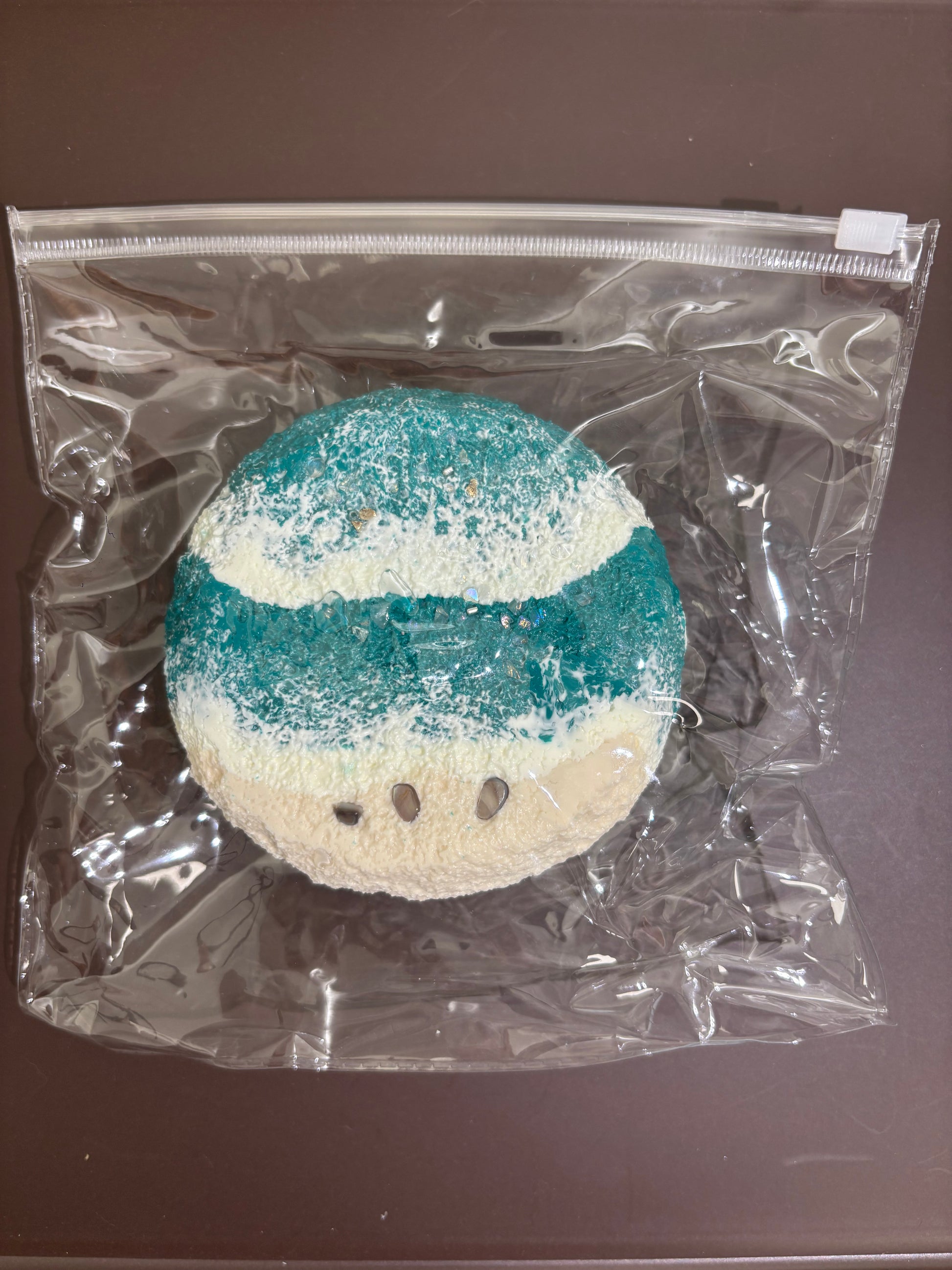 丸型入浴剤（青緑×クリーム層、透明袋入り）